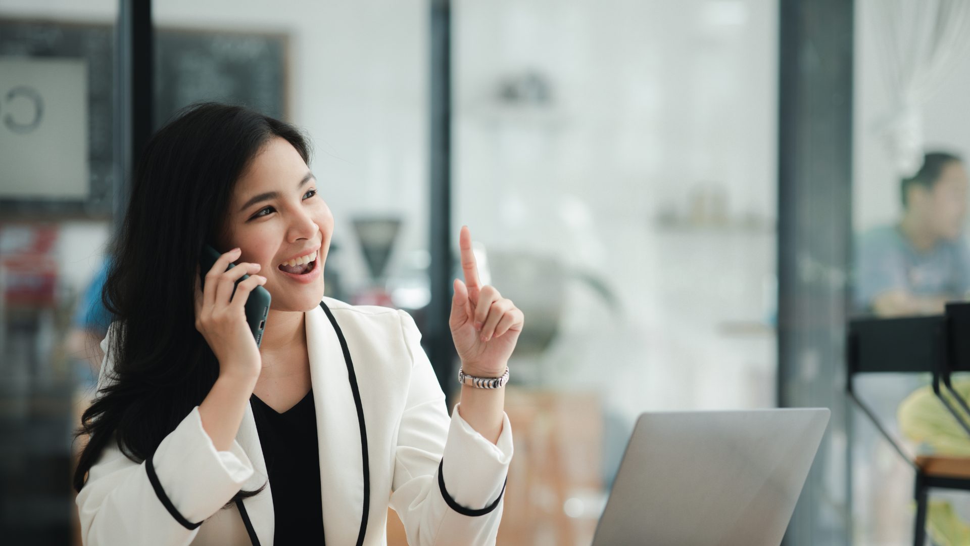 A businesswoman talking on her phone in a bright open-plan office